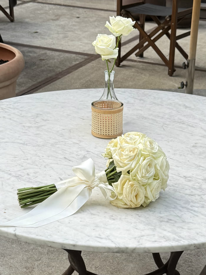 A bouquet of white roses on a marble café table