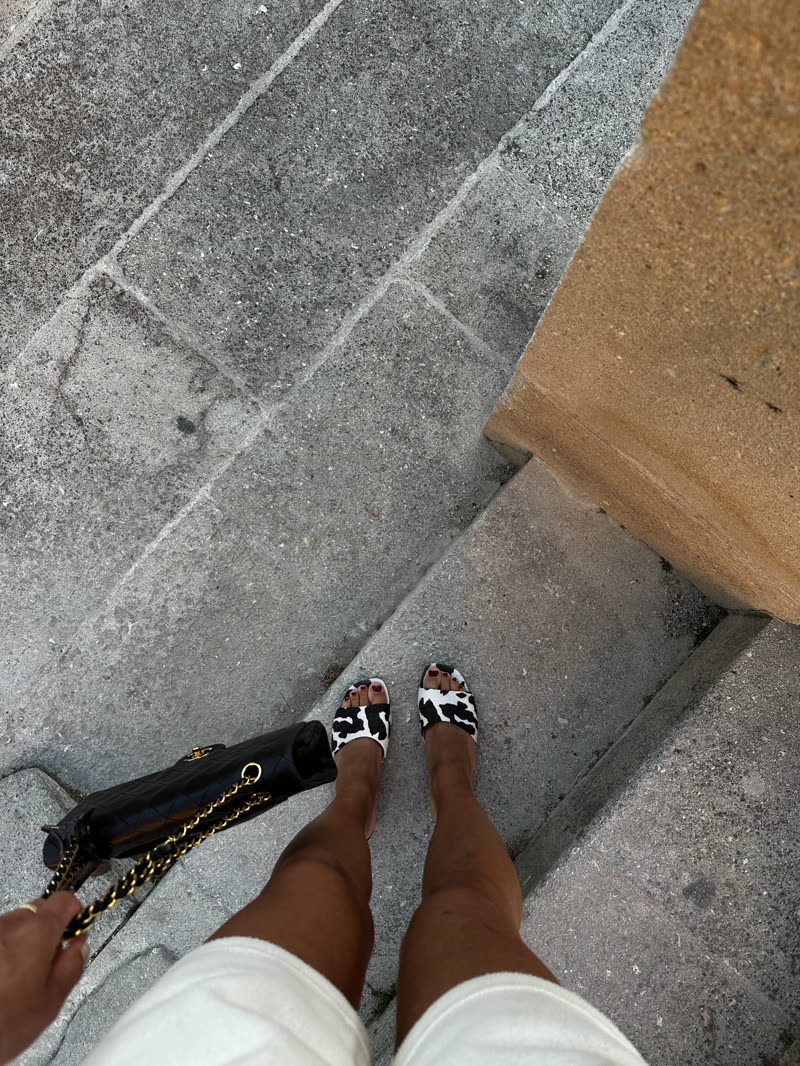 Printed sandals and a chain bag on stone steps, seen from above