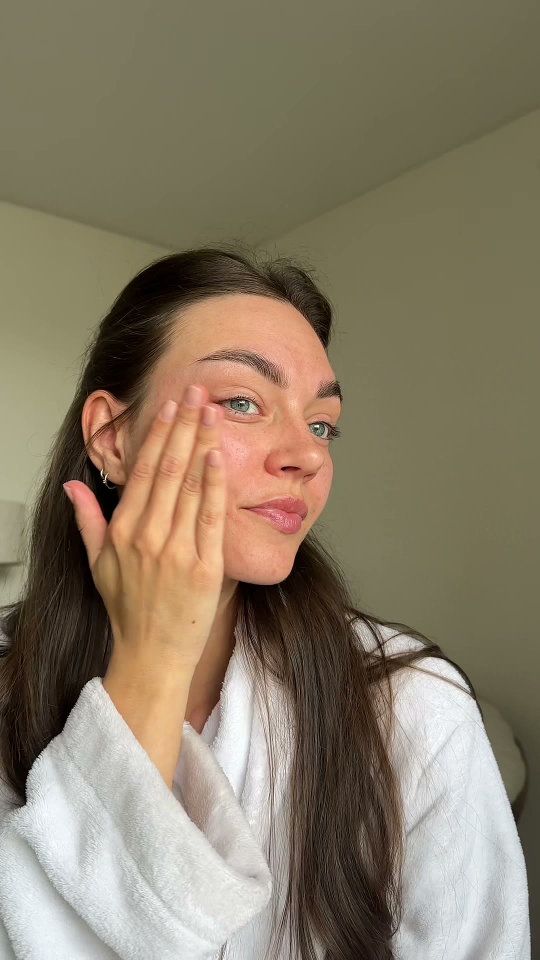 Sabine applying skincare to her cheek